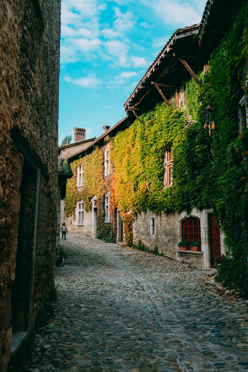 Sunlit peaceful cobblestone alley in old European town